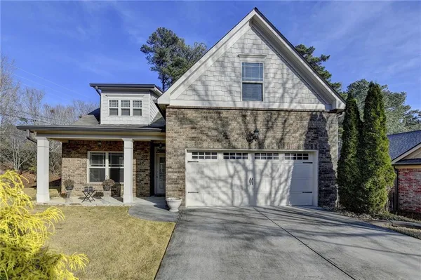 a view of a house with a yard and potted plants