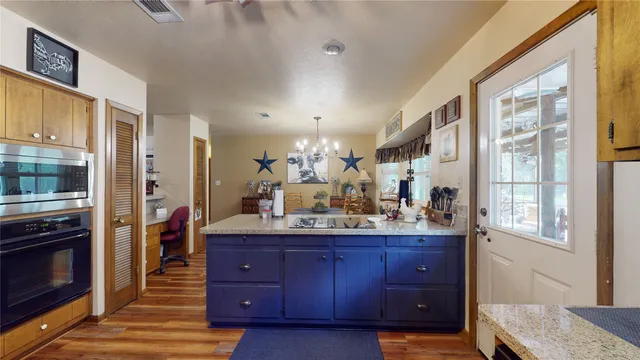 a kitchen with granite countertop a refrigerator and cabinets