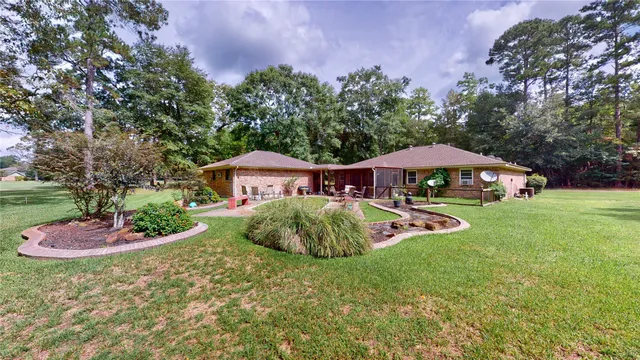 a view of a house with backyard and trees