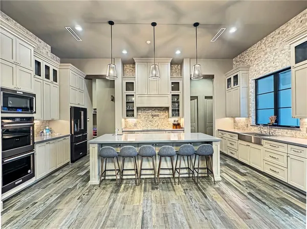 a dining room with stainless steel appliances kitchen island granite countertop furniture and a fireplace