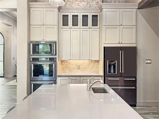 a kitchen with stainless steel appliances granite countertop a refrigerator and a stove top oven