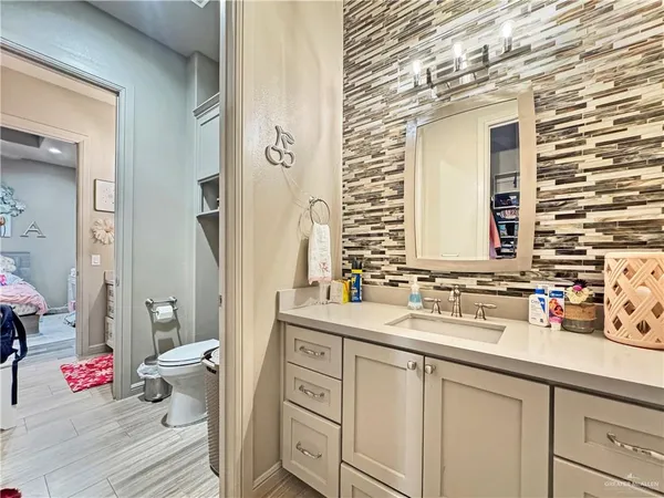 a bathroom with a sink mirror and toilet