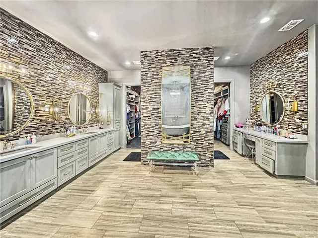 a large bathroom with double vanity sink a mirror and next to a window