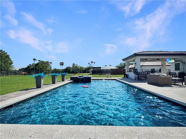 a swimming pool with outdoor seating and yard