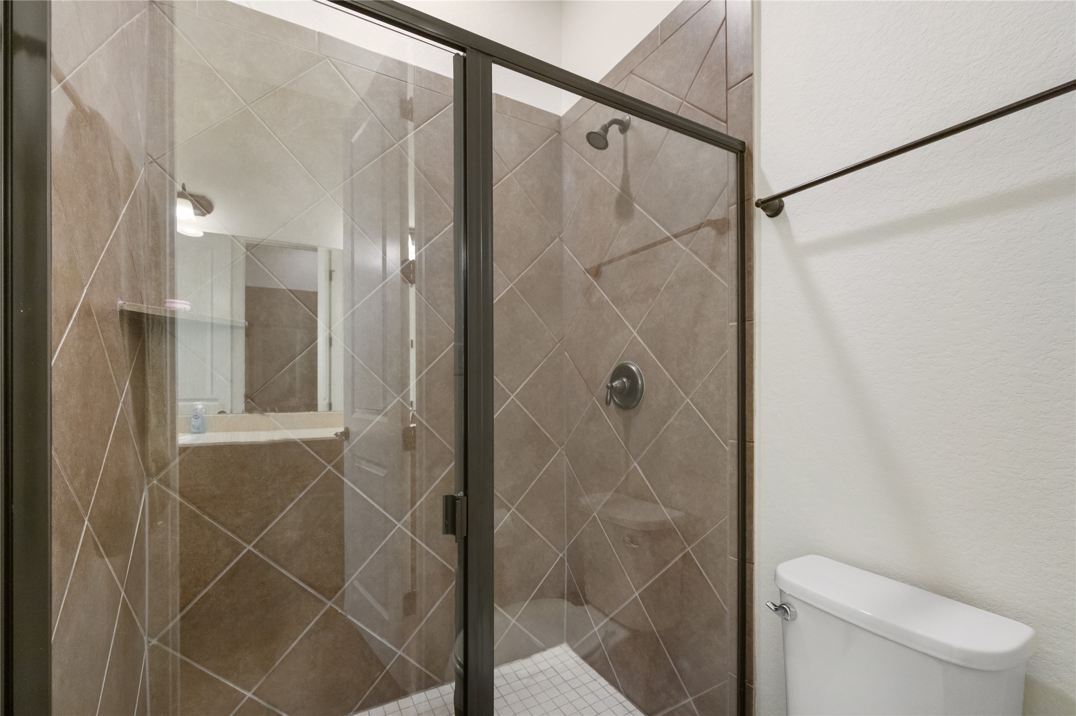 415 Bitterroot Lane Austin, TX 78737 - Photo 19 of 25 A well-appointed shower stall features diagonal tile work and a sleek glass enclosure.
