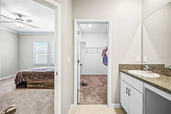 a en suite bathroom with a granite countertop sink and a mirror