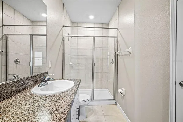 a bathroom with a sink shower and a mirror