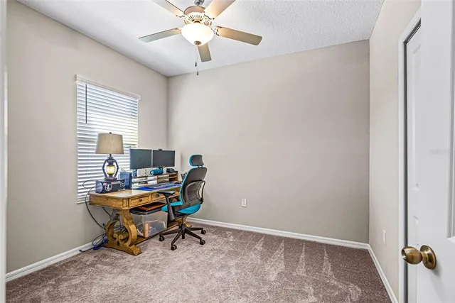 a view of a workspace with furniture and a window