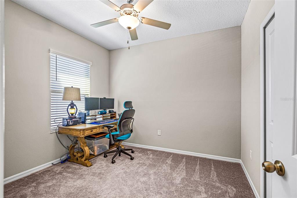 31945 Blue Passing Loop Wesley Chapel, FL 33545 - Photo 17 of 22 a view of a workspace with furniture and a window