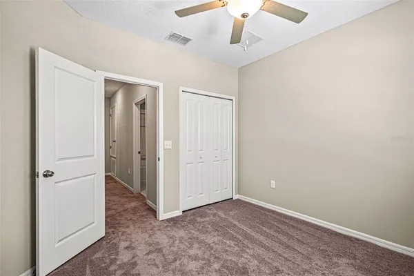 an empty room with a ceiling fan and a window