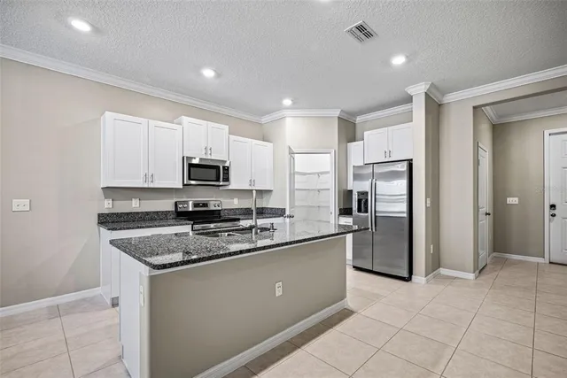 a kitchen with stainless steel appliances granite countertop a refrigerator and a stove top oven