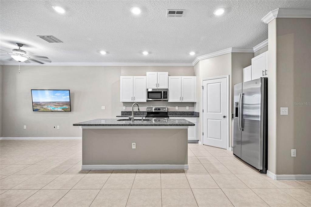 31945 Blue Passing Loop Wesley Chapel, FL 33545 - Photo 5 of 22 a kitchen with stainless steel appliances granite countertop a refrigerator and a stove