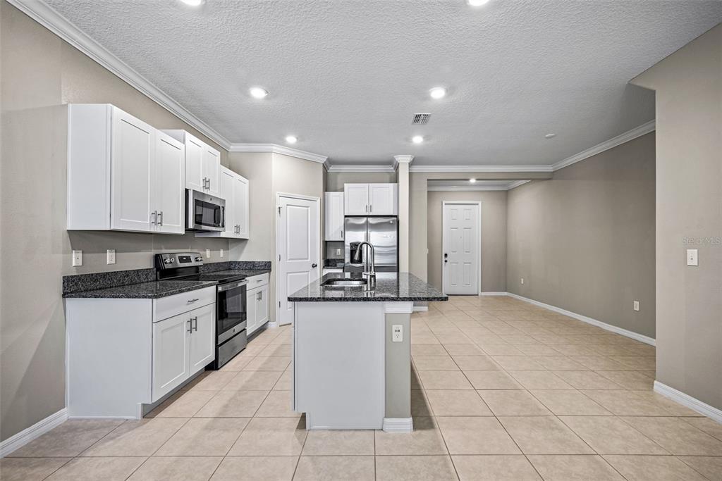 31945 Blue Passing Loop Wesley Chapel, FL 33545 - Photo 7 of 22 a kitchen with stainless steel appliances granite countertop a stove and a sink