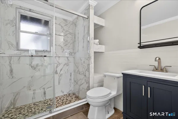 a bathroom with a sink a toilet and shower