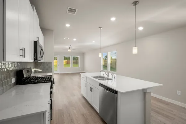 a kitchen with counter top space cabinets and appliances