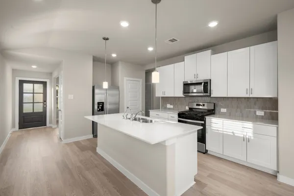 a kitchen with counter top space sink stove and refrigerator