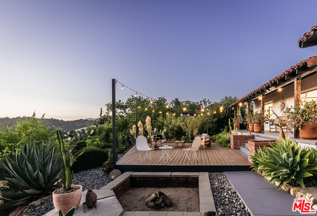 a view of a patio with couches table and chairs and potted plants