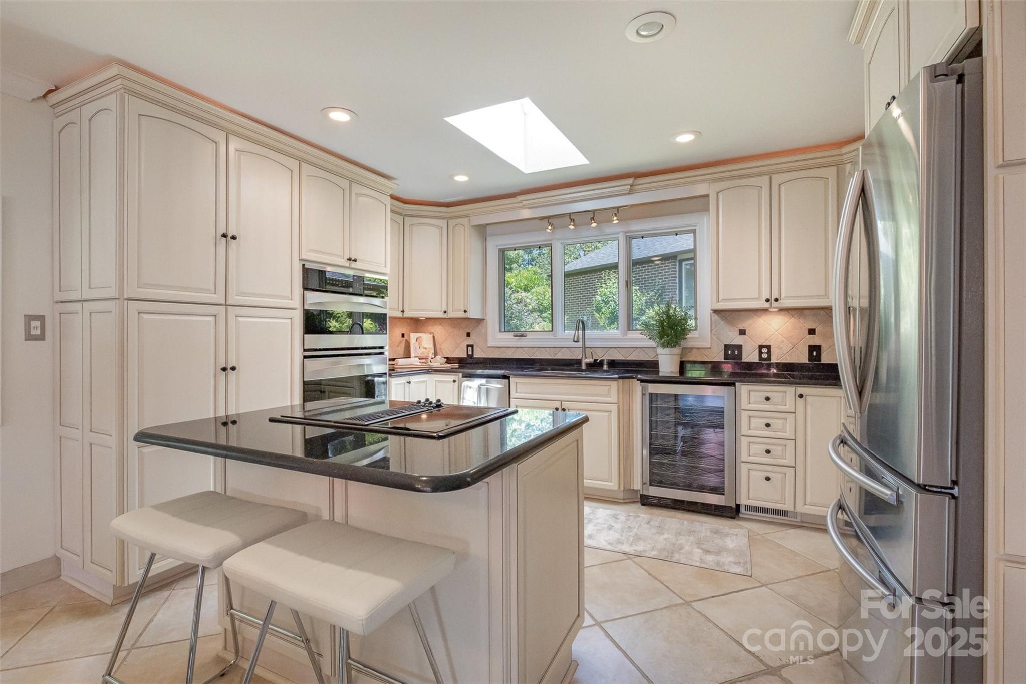 9500 Windygap Road Charlotte, NC 28278 - Photo 11 of 48 a kitchen with kitchen island granite countertop a stove a sink a refrigerator and white cabinets with wooden floor