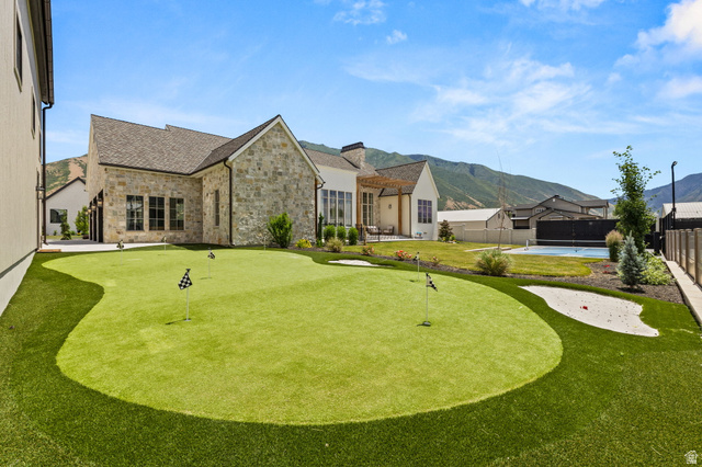 478 South Maple Lakes Drive Mapleton, UT 84664 - Photo 42 of 51 Expansive backyard featuring a multi-hole putting green with sand trap, integrated artificial turf, stone exterior, and a mountain backdrop
