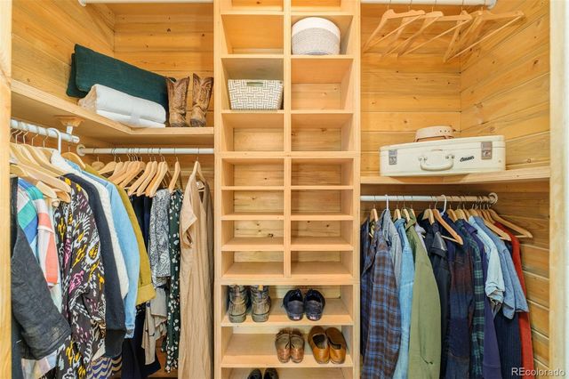 a view of walk in closet with clothes and shoes