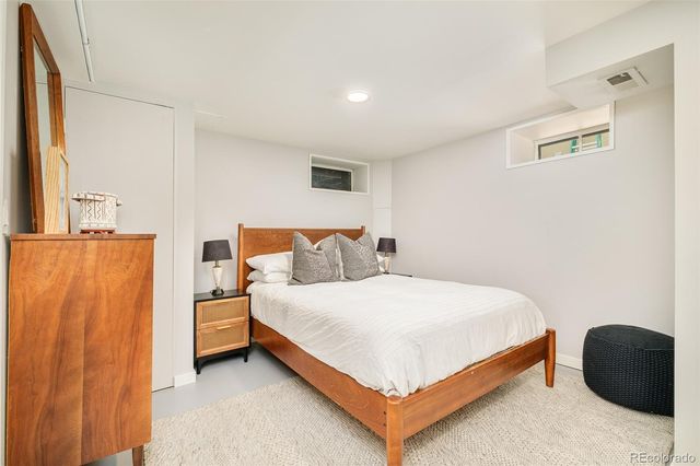 a bedroom with a bed and a painting on the wall