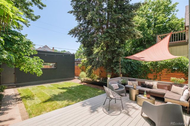 a view of backyard with seating area and trees