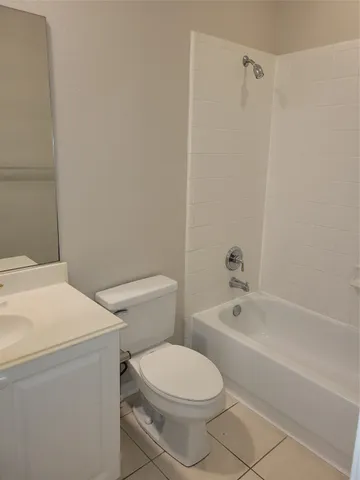 a white toilet sitting next to a bath tub