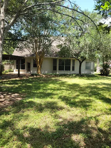 a front view of house with yard and trees around
