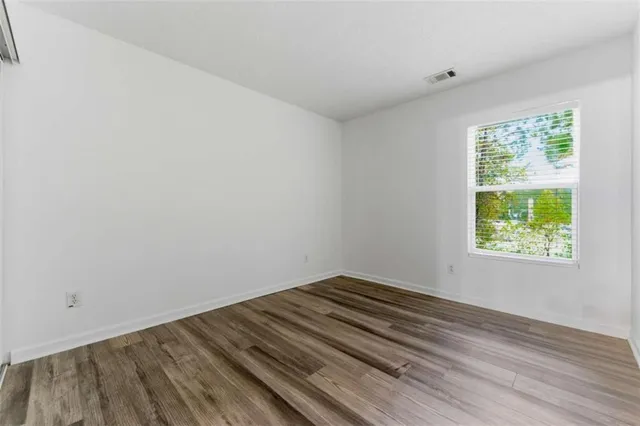 a view of a room with wooden floor and window