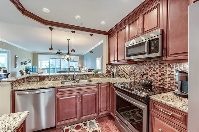 a kitchen with stainless steel appliances granite countertop a sink stove and cabinets