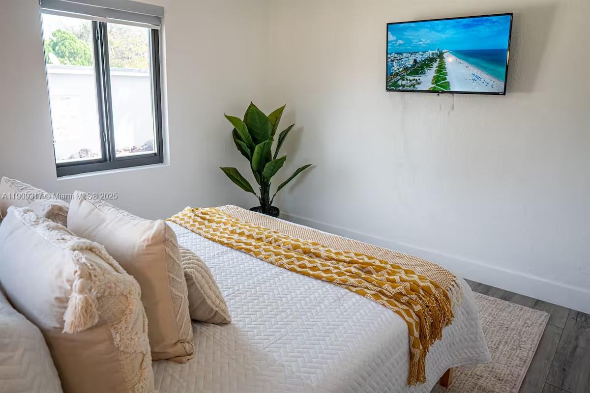 271 Northwest 143rd Street Miami, FL 33168 - Photo 20 of 43 a bedroom with a bed and a painting on the wall