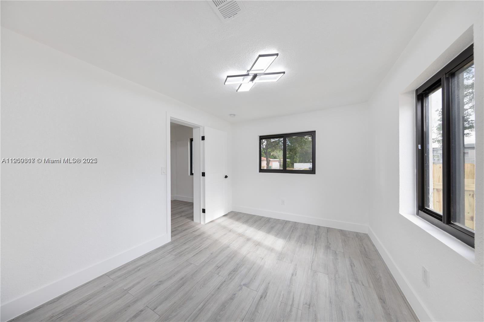 271 Northwest 143rd Street Miami, FL 33168 - Photo 27 of 43 a view of empty room with wooden floor and fan