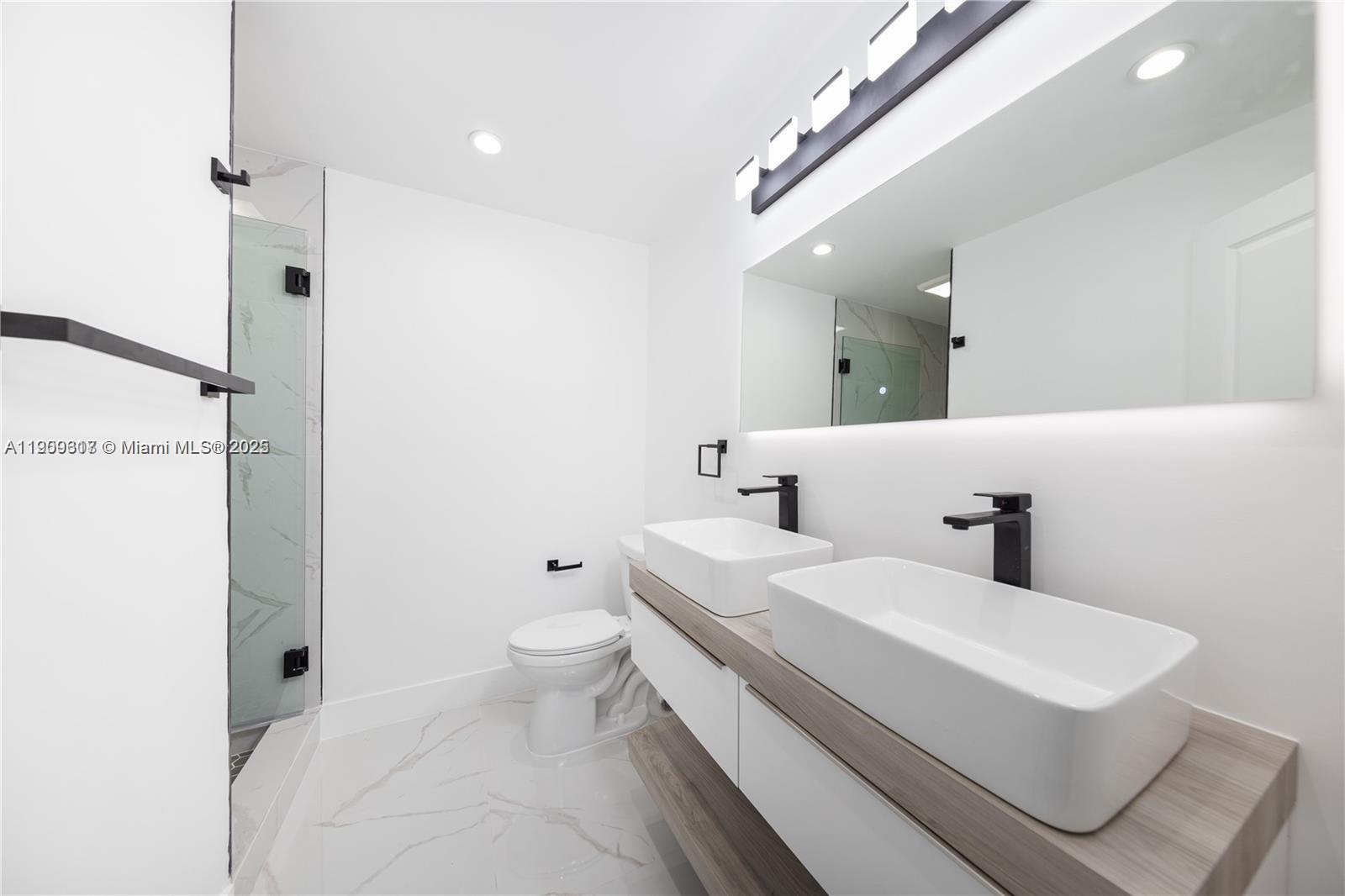 271 Northwest 143rd Street Miami, FL 33168 - Photo 29 of 43 a bathroom with a sink a toilet and a mirror