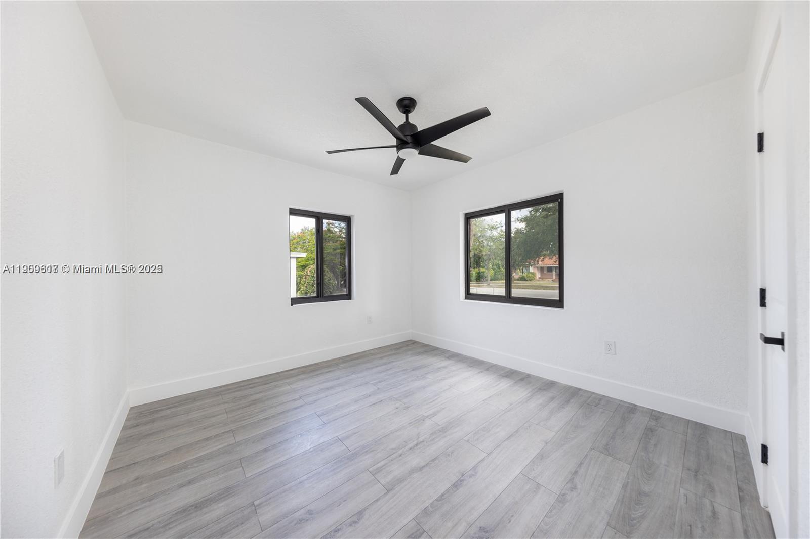 271 Northwest 143rd Street Miami, FL 33168 - Photo 32 of 43 an empty room with wooden floor ceiling fan and windows