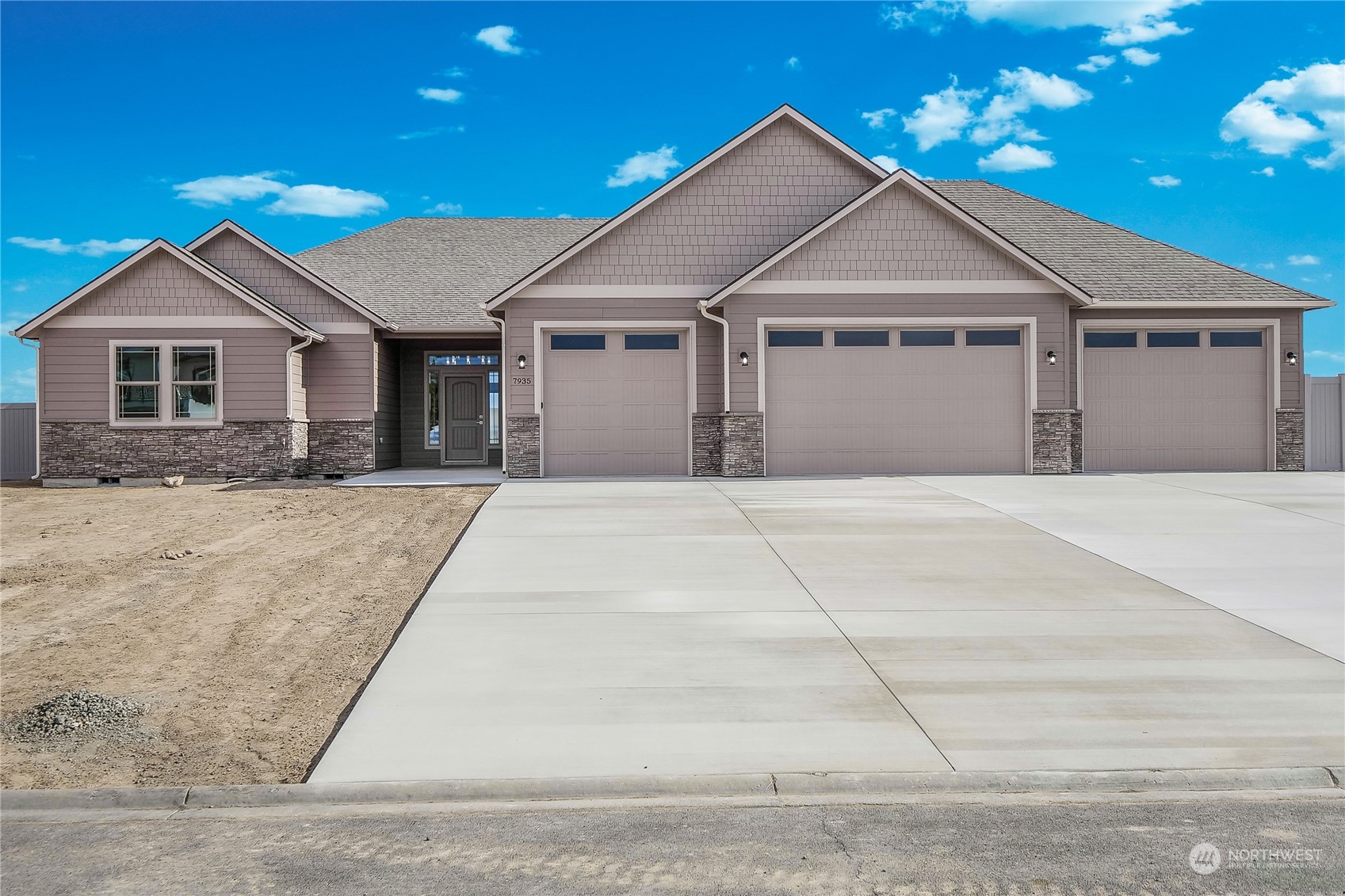 a front view of house with yard and trees in the background