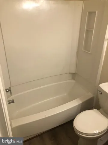a white toilet sitting next to a bath tub