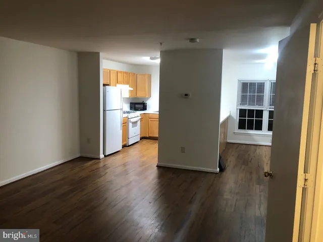 a view of a kitchen with wooden floor and a window