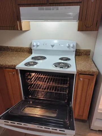 a stove top oven sitting inside of a kitchen