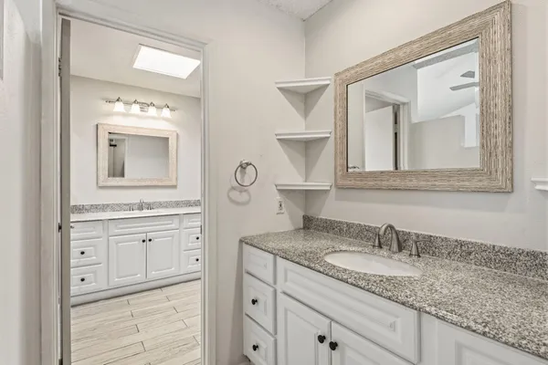 a bathroom with a granite countertop sink vanity and mirror