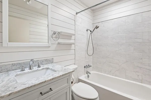 a bathroom with a granite countertop sink toilet and shower