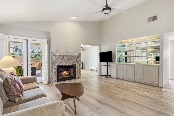 a living room with furniture a flat screen tv and a fireplace