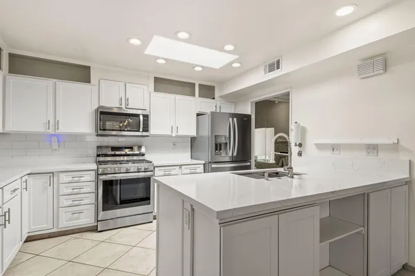 a kitchen with appliances a sink cabinets and a counter top space