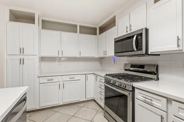a kitchen with cabinets stainless steel appliances and a sink