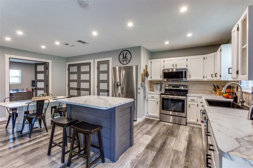2033 Rose Hill Road Carrollton, TX 75007 - Photo 1 of 1 a kitchen with kitchen island granite countertop lots of counter top space and stainless steel appliances