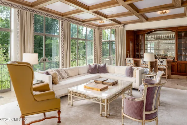 a living room with furniture a large window and wooden floor