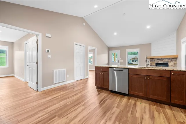 a large kitchen with wooden floors and stainless steel appliances