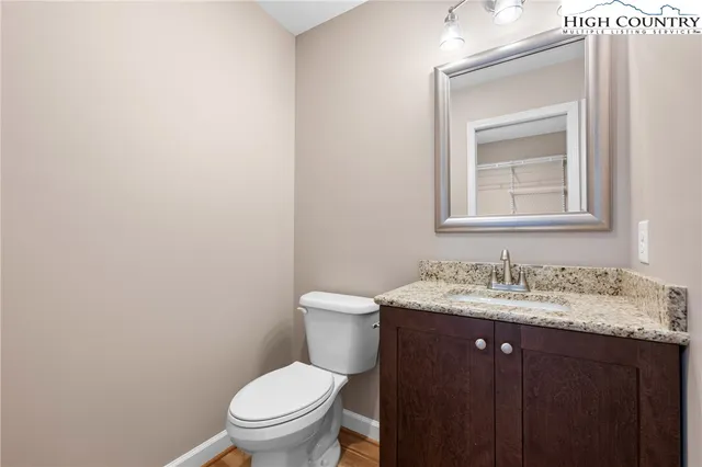 a bathroom with a granite countertop toilet sink and mirror