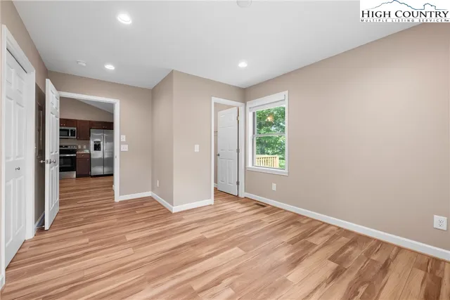 a view of a hallway with wooden floor and a living room