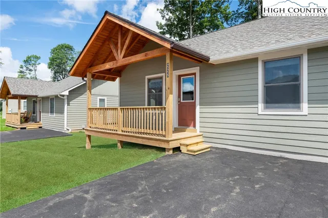 a backyard of a house with deck and outdoor seating