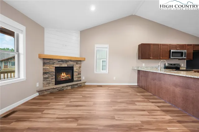 a view of kitchen with granite countertop stove top oven and sink